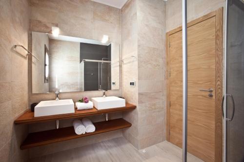 a bathroom with two sinks and a mirror at Santerra - San Jose in Cala Bassa