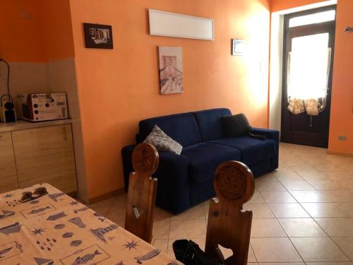 sala de estar con sofá azul y mesa en One bedroom apartement with terrace at Bersezio 1 km away from the slopes, 