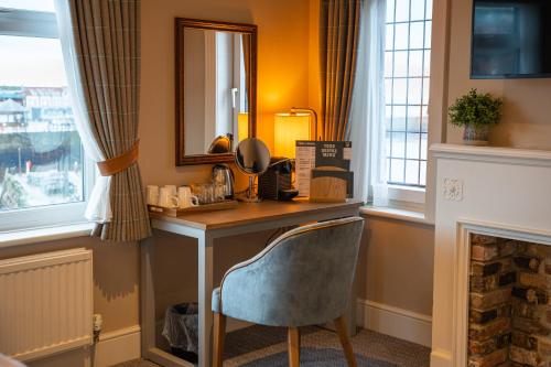 a desk in a room with a mirror and a chair at Duke of York in Whitby