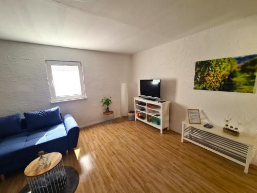 sala de estar con sofá azul y TV en Urlaub beim Winzer, en Klingenmünster