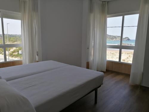 um quarto com uma cama e vista para a praia em Apartamentos Regollera Premium con garaje em Noja