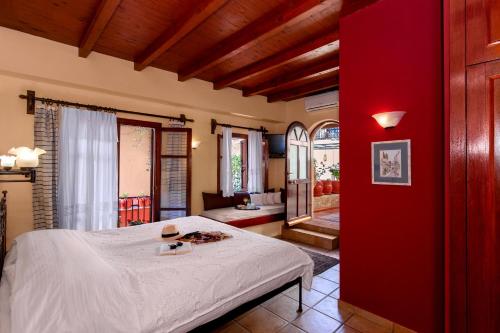 a bedroom with a bed and a red wall at Veneto Boutique Hotel in Rethymno Town