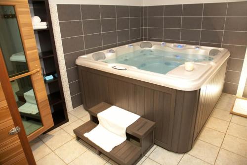 ein Bad mit einer Badewanne und einem Handtuch in der Unterkunft Le Bretagne - Hôtel Spa & Sauna in Douarnenez