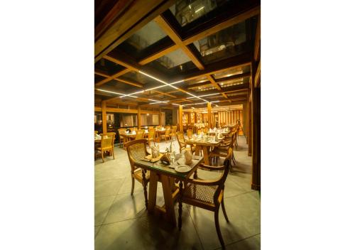 a dining room with wooden tables and chairs at Chandys Drizzle Drops - Munnar Top Station in Munnar