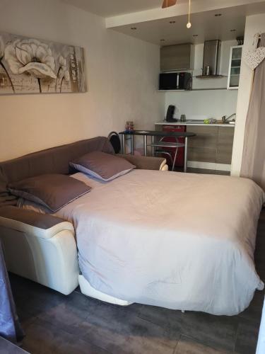 Cette chambre comprend un grand lit et un canapé. dans l'établissement Studio RDC, terrasse, parking, à Bandol
