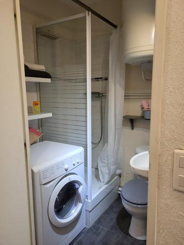 une petite salle de bains avec un lave-linge et des toilettes. dans l'établissement Studio RDC, terrasse, parking, à Bandol