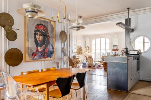 une cuisine et une salle à manger avec une table et des chaises en bois dans l'établissement Veeve - Impressions of the Eiffel Tower, à Paris