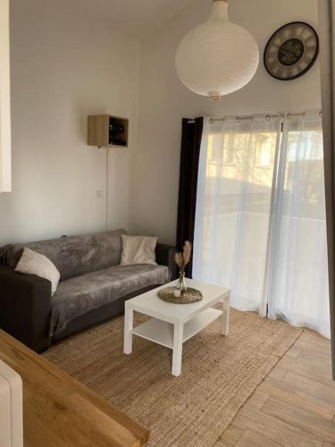 a living room with a couch and a coffee table at Logement avec mezzanine in Tremblay En France
