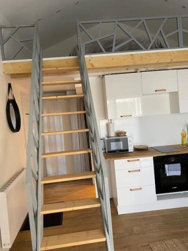 a stairway leading up to a bunk bed in a kitchen at Logement avec mezzanine in Tremblay En France