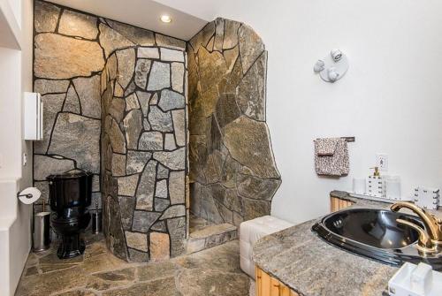 a stone shower in a bathroom with a sink at Starlight Boutique Hotel Pioneertown in Pioneertown