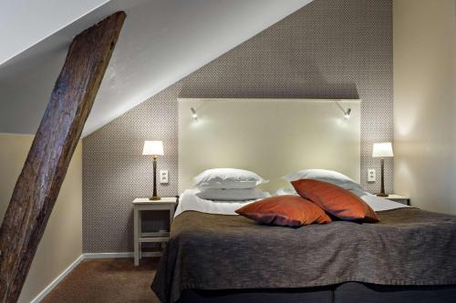 a bedroom with a bed with two pillows on it at Best Western Plus Edward Hotel in Lidköping