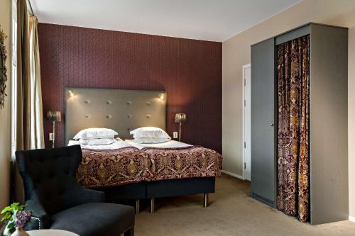 a bedroom with a bed and a chair at Best Western Plus Edward Hotel in Lidköping