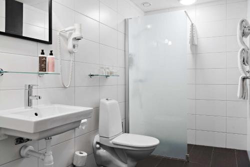 a bathroom with a toilet and a sink and a shower at Best Western Plus Edward Hotel in Lidköping