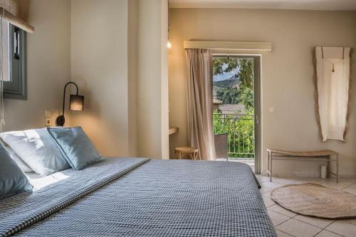 een slaapkamer met een bed en een deur naar een patio bij Unique Kefalonia Ionian Sands Villa in Lourdhata