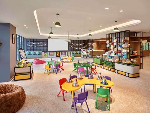 a childrens play area with tables and colorful chairs at Premier Residences Phu Quoc Emerald Bay Managed by Accor in Phú Quốc
