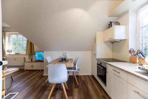 a kitchen with a table and chairs in a room at Ferienwohnung Klintum in Oldsum