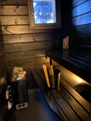 a bench in a room with a table and a window at Paritalomökki Lomariihi 4 in Muurame