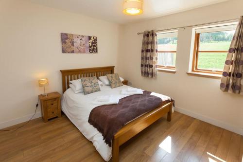 1 dormitorio con cama y ventana en Laurel Cottage at Williamscraig Holiday Cottages, en Linlithgow