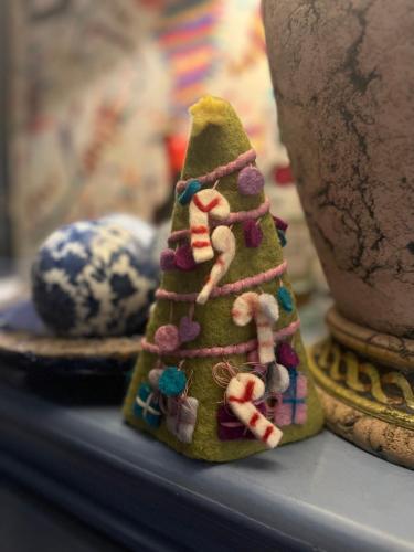 a small green christmas tree sitting on a shelf at La casa di Ciaccia in Camaiore