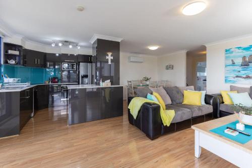 a large living room with a couch and a kitchen at Heritage 302 in Tuncurry