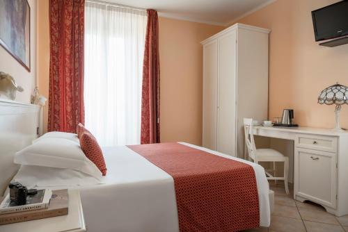 1 dormitorio con cama, escritorio y ventana en Hotel Mayer & Splendid - Wellness e Spa en Desenzano del Garda