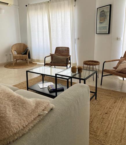 a living room with a couch and tables and chairs at Appartement Casa Lina Lagos vue mer in Lagos