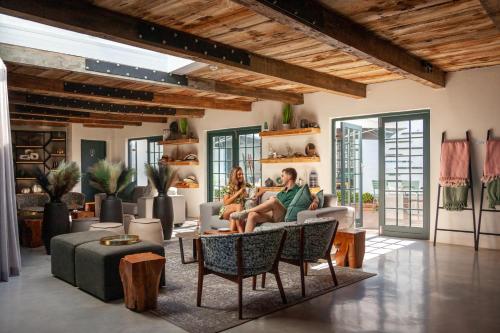 Abalone Hotel & Villa's في باتيرنوستير: يجلس شخصان على أريكة في غرفة المعيشة