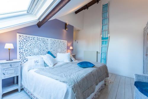 a bedroom with a bed with a blue pillow on it at B&B Yasmine Brugge in Bruges