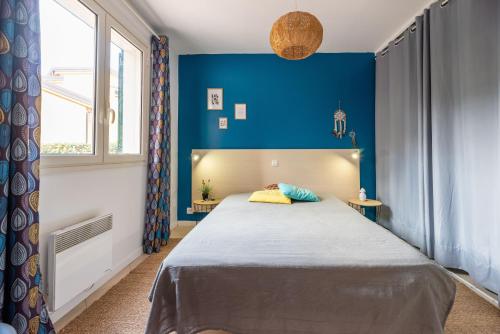 une chambre avec un lit avec un mur bleu dans l'établissement A Muredda di Lozari, à Belgodère