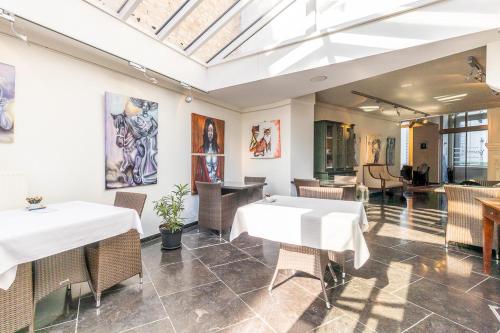 a dining room with tables and chairs and a skylight at B&B Yasmine Brugge in Bruges