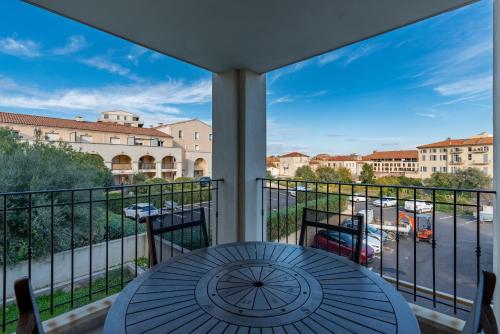 a balcony with a table and a view of a street at Isula Rossa in LʼÎle-Rousse