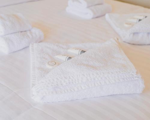 uma pilha de toalhas brancas numa cama em Port Broughton Hotel and Sunnyside Motel em Port Broughton