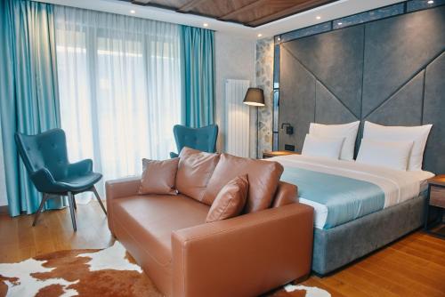Hotel Zlatibor في زلاتيبور: غرفه فندقيه بسرير واريكه