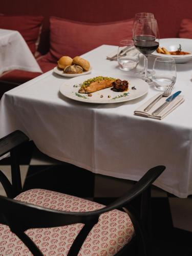 a white table with a plate of food and a glass of wine at Hotel Morfeo in Milan