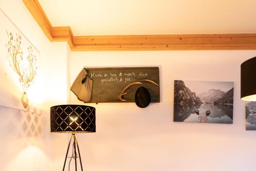 a sign on a wall with pictures and a lamp at Appartements Kirchenwirt in Kirchberg in Tirol