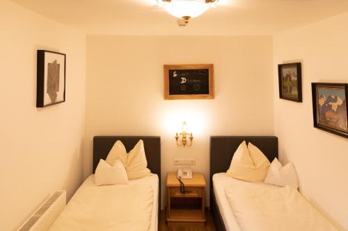 two beds in a room with white sheets and pillows at Appartements Kirchenwirt in Kirchberg in Tirol