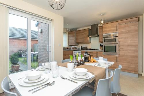 a kitchen with a table with white plates and silverware at The Fusiliers in Leyland