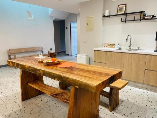 uma mesa de madeira numa cozinha com um lavatório em Rooms Homestay em Hualien
