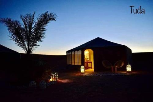 ザゴラにあるDesert Campの夜間の砂漠灯付小さな建物