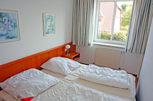 um quarto com 2 camas e uma janela em Apartment 7 em Heiligenhafen