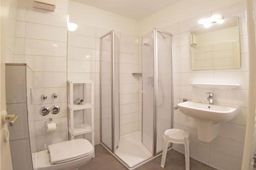 uma casa de banho com um chuveiro, um lavatório e um WC. em Apartment 7 em Heiligenhafen