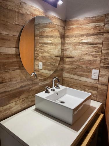 a bathroom with a white sink and a mirror at La Reserva in Villa Parque Siquiman