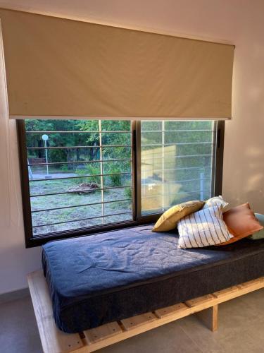 uma cama num quarto com uma grande janela em La Reserva em Villa Parque Síquiman