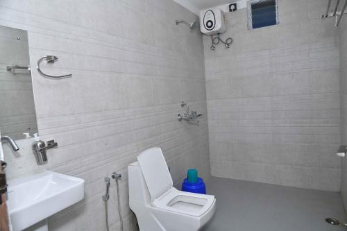 a white bathroom with a toilet and a sink at Hotel Lake View in Port Blair