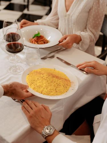 a group of people sitting at a table with a plate of food at Hotel Morfeo in Milan