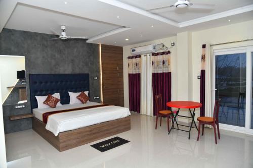 Hotel Lake View في ميناء بلير: غرفة نوم بسرير وطاولة وكراسي
