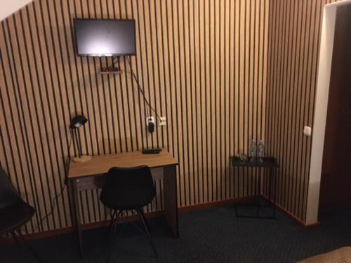a room with a desk with a lamp and a chair at Hotel Na Wzgórzu in Gniew