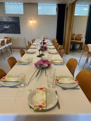 a long table with plates and flowers on it at Molde Vandrerhjem Hostel in Molde