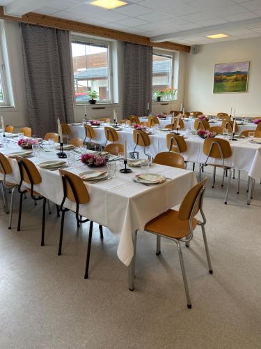a room with tables and chairs with white tablecloths at Molde Vandrerhjem Hostel in Molde