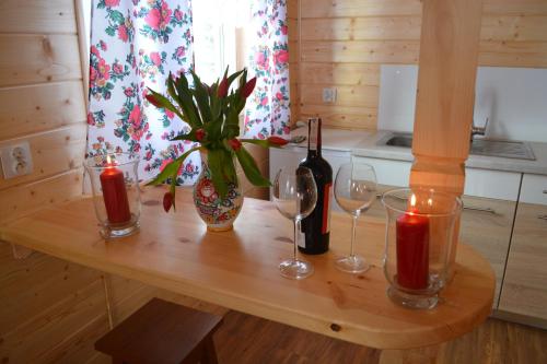 a wooden table with two wine glasses and a plant at Domki nad Ripką in Wysowa-Zdrój